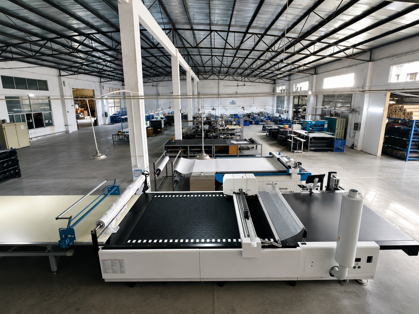 Huixing saddle cutting workshop with automated cutting tables, material rolls, and organized production lanes.
