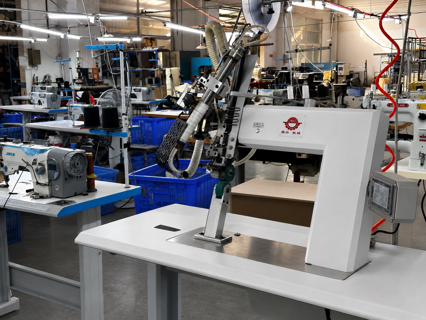 Huixing saddle trim press workstation with industrial sewing and seat-cover equipment on the production floor.